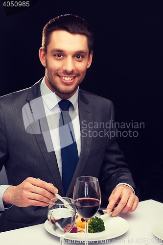 Image of smiling man eating main course