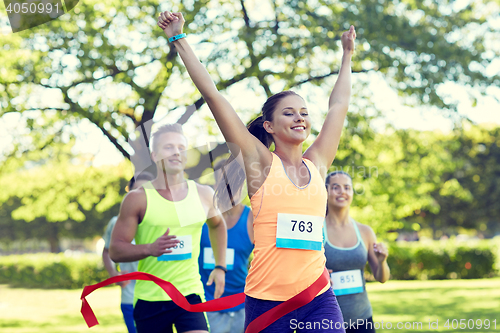 Image of happy young female runner winning on race finish
