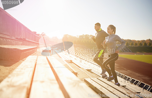 Image of happy couple running upstairs on stadium