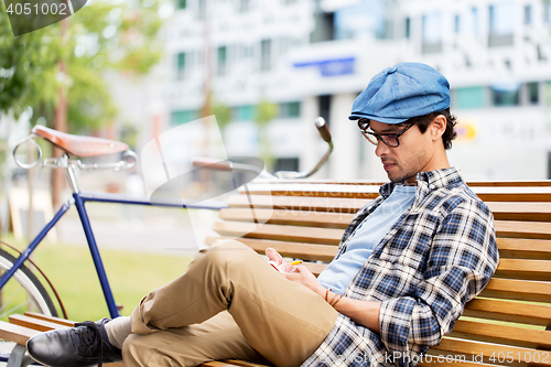 Image of man with notebook or diary writing on city street