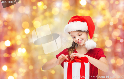 Image of smiling girl in santa hat with christmas gift