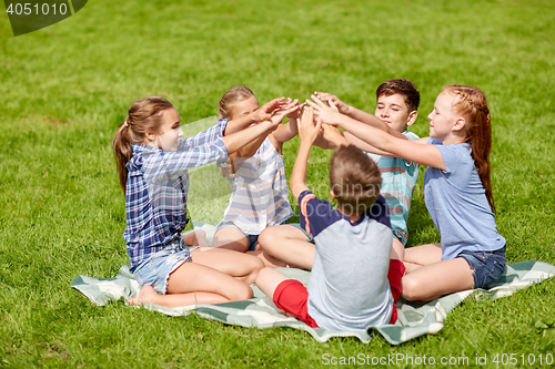 Image of group of happy kids putting hands together