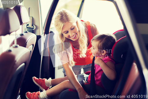 Image of happy mother fastening child with car seat belt