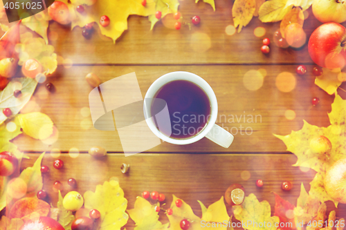 Image of close up of tea cup on table with autumn leaves