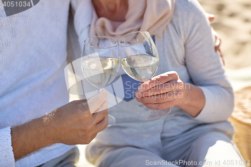 Image of happy senior couple drinking wine on summer beach