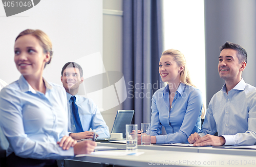 Image of group of smiling businesspeople meeting in office