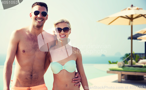 Image of happy couple in swimwear hugging over hotel resort