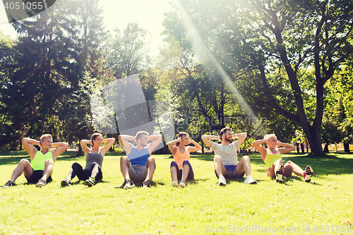 Image of group of friends or sportsmen exercising outdoors