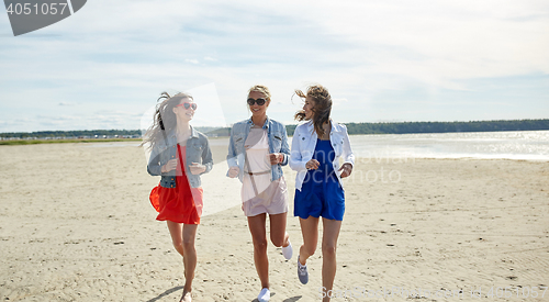 Image of group of smiling women in sunglasses on beach