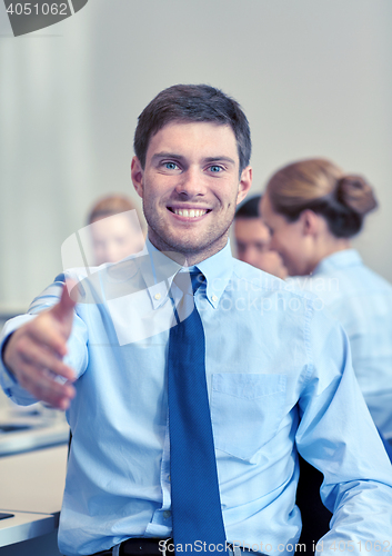 Image of group of smiling businesspeople meeting in office