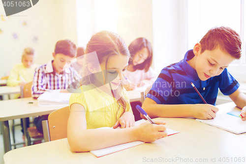 Image of group of school kids writing test in classroom