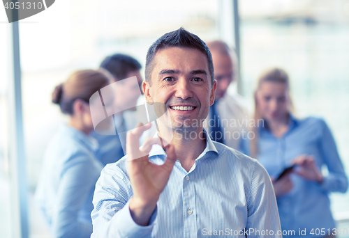 Image of group of smiling businesspeople meeting in office