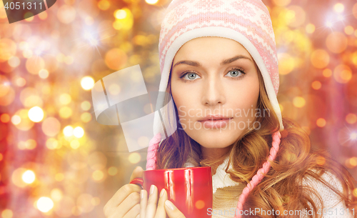 Image of young woman in winter clothes with tea cup