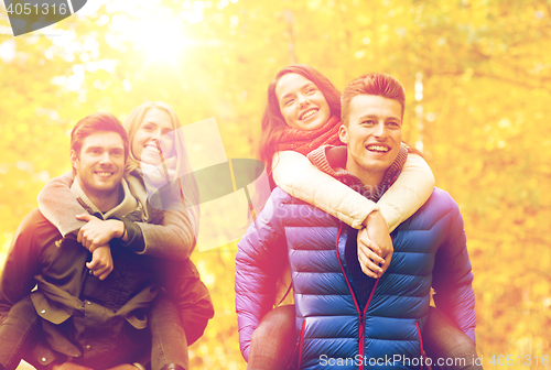 Image of smiling friends having fun in autumn park