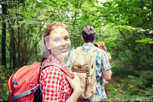 Image of group of smiling friends with backpacks hiking