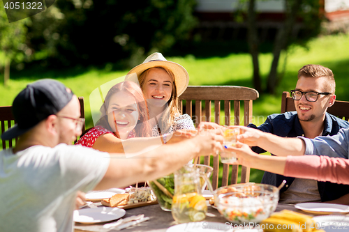 Image of happy friends having dinner at summer garden party