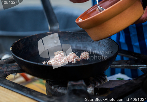 Image of forcemeat on frying pan at street market