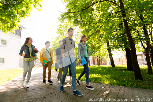 Image of group of happy teenage students walking outdoors