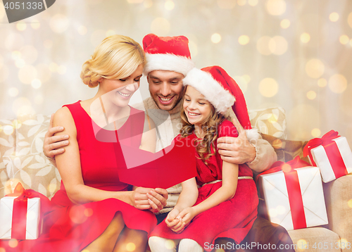 Image of smiling family reading postcard