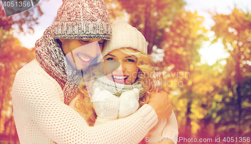 Image of happy couple in warm clothes over autumn