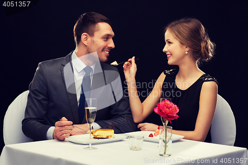 Image of smiling couple eating dessert at restaurant