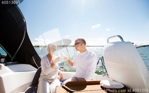 Image of senior couple clinking glasses on boat or yacht