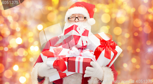 Image of man in costume of santa claus with gift boxes