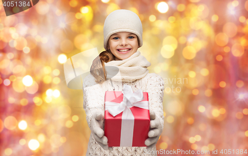 Image of happy girl in hat, scarf and gloves with gift box