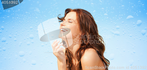 Image of happy beautiful woman over wet blue background