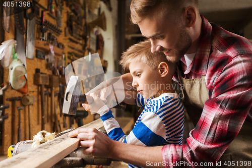 Image of father and son with hammer working at workshop