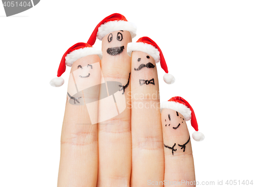 Image of close up of hand with four fingers in santa hats