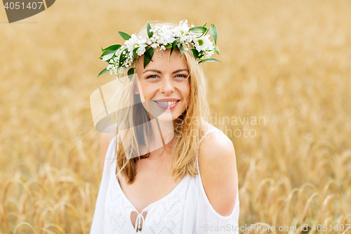 Image of happy young woman in flower wreath on cereal field