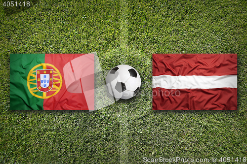 Image of Portugal vs. Latvia flags on soccer field