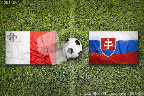 Image of Malta vs. Slovakia flags on soccer field