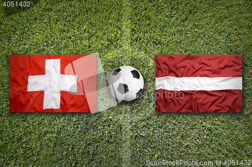 Image of Switzerland vs. Latvia flags on soccer field