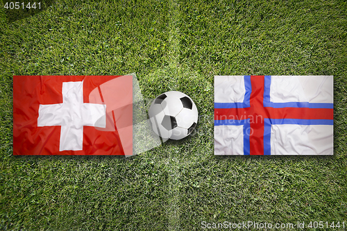 Image of Switzerland vs. Faroe islands flags on soccer field