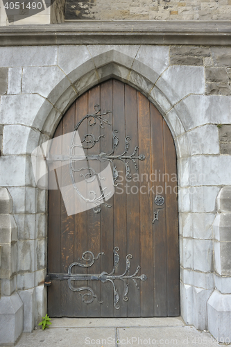 Image of old wooden door with iron ornaments