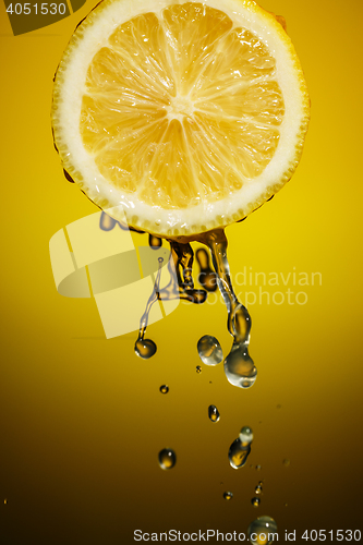 Image of One half of lemon with fresh water drops isolated on colorful background