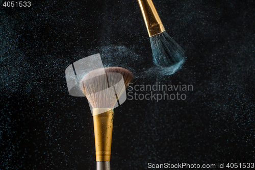 Image of Make-up brushes with powder isolated on black background