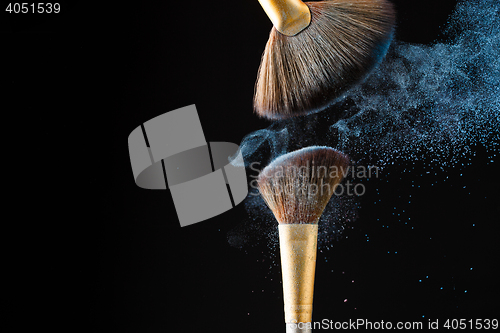 Image of Beautiful splash after touch of two professional brushes on black background