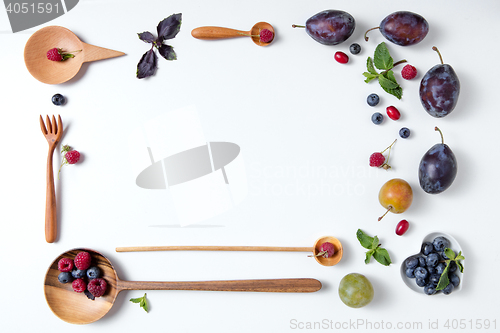 Image of frame of spoons with berries and plums