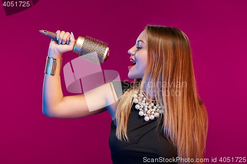 Image of Female stylist standing with hairdresser\'s accessories