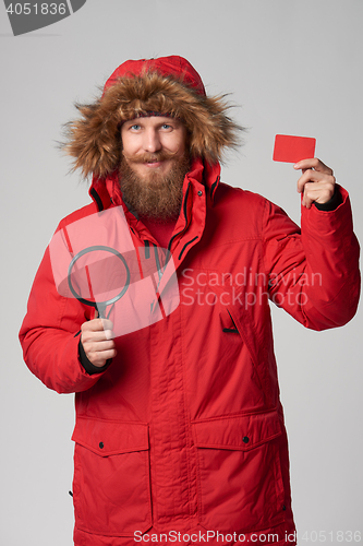 Image of Man wearing red winter Alaska jacket with fur hood on