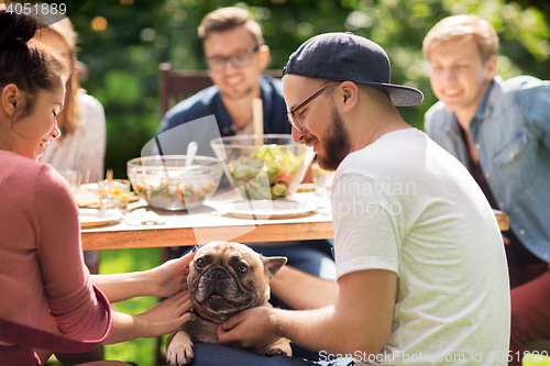 Image of happy friends having dinner at summer garden party