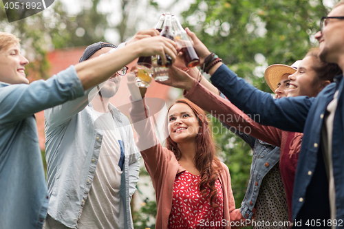 Image of happy friends clinking glasses at summer garden