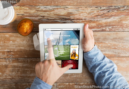 Image of close up of hands with news page on tablet pc