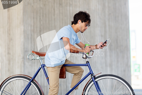 Image of man with smartphone and earphones on bicycle