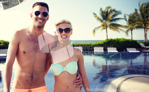 Image of happy couple in swimwear hugging over hotel resort