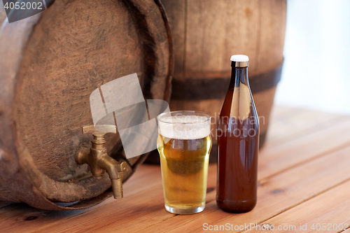 Image of close up of old beer barrel, glass and bottle