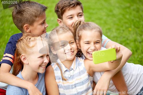 Image of happy kids or friends taking selfie in summer park